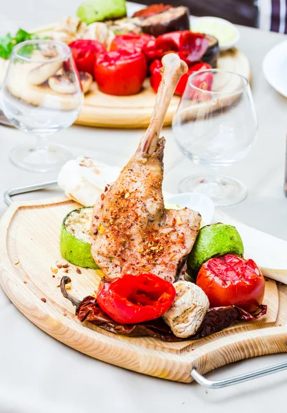 Muslos de pollo al horno con especias y verduras a la parrilla en un woo —  Fotos de Stock