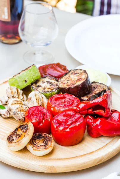 Verduras a la parrilla y champiñones con salsa en una tabla de madera —  Fotos de Stock