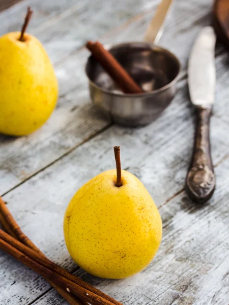 Ahşap bir masa, tarçın, sağlıklı snack üzerinde sarı armut — Stok fotoğraf