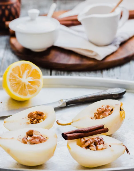 Cooking process pear with walnuts, cinnamon sticks on an iron pl — Stock Photo, Image