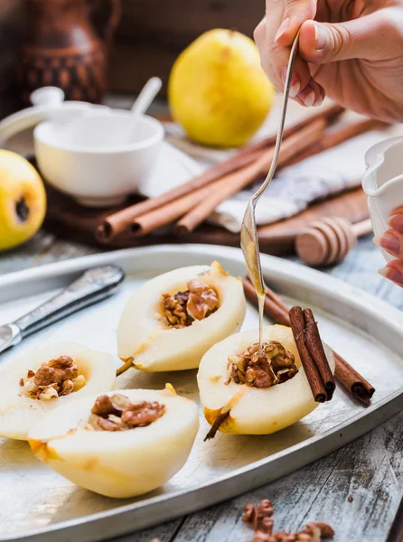 Bir armut prosedürü pişirme, ceviz, tarçın sopa ile bal ekleyin — Stok fotoğraf