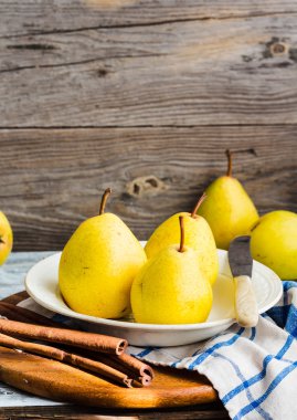 Ahşap bir masa, tarçın, Natürmort üzerinde taze sarı armut