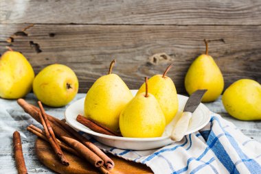 Ahşap bir masa, tarçın, Natürmort üzerinde taze sarı armut