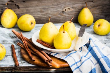Ahşap bir masa, tarçın, Natürmort üzerinde taze sarı armut