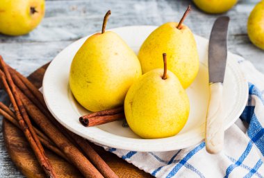 Ahşap bir masa, tarçın, Natürmort üzerinde taze sarı armut