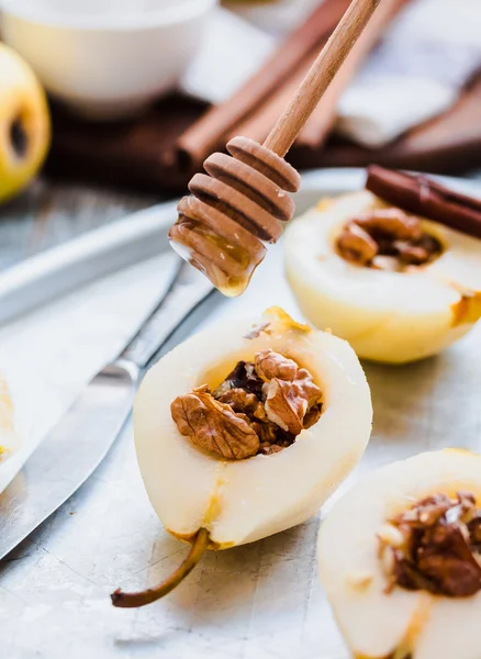 Груша с грецкими орехами и медом перед выпечкой, коричные палочки — стоковое фото