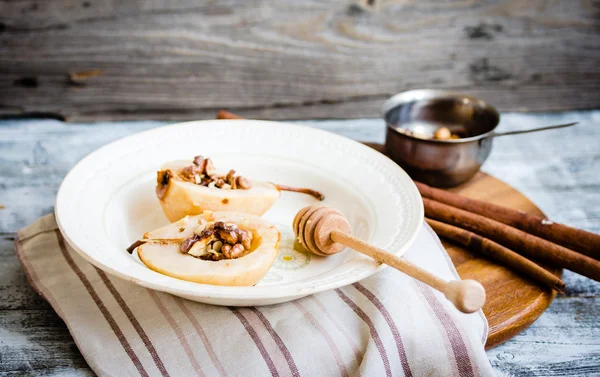 Spicy baked pear with walnuts, honey, cinnamon sticks, healthy d — Stock Photo, Image