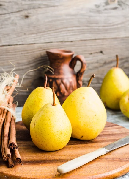 Färska gula päron på en planka, kanelstänger, stilleben — Stockfoto