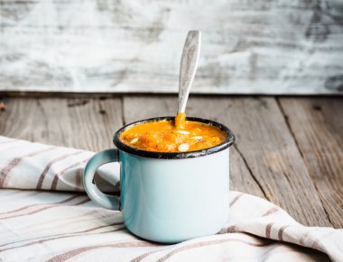 Mavi bir kupa, rustik arka plan sonbahar balkabağı çorbası