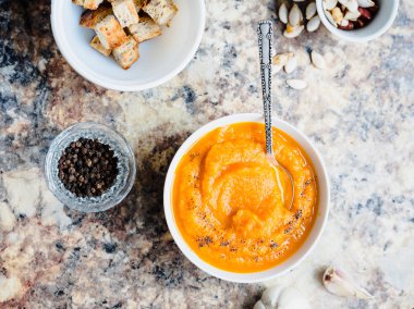 Beyaz bir tabak içinde sonbahar balkabağı çorbası vegan akşam yemeği