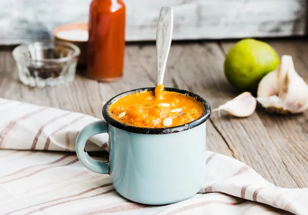 Autumn pumpkin soup in a blue mug, rustic background — Stock Photo, Image