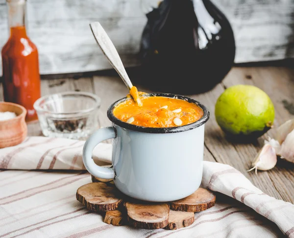 Autumn pumpkin soup in a blue mug, rustic background,tinting — Stock Photo, Image