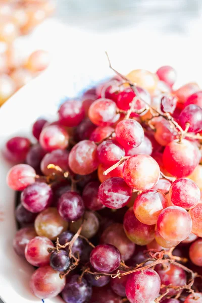 Onların elinde bir tabak taze kırmızı üzüm, tutun çiğ meyve — Stok fotoğraf