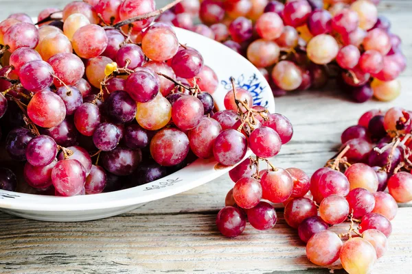 Uvas vermelhas frescas no prato, frutas cruas, alimentos integrais vegetais — Fotografia de Stock