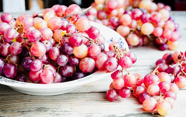 Färska röda druvor på plattan, råa frukter, hela vegetabilier — Stockfoto