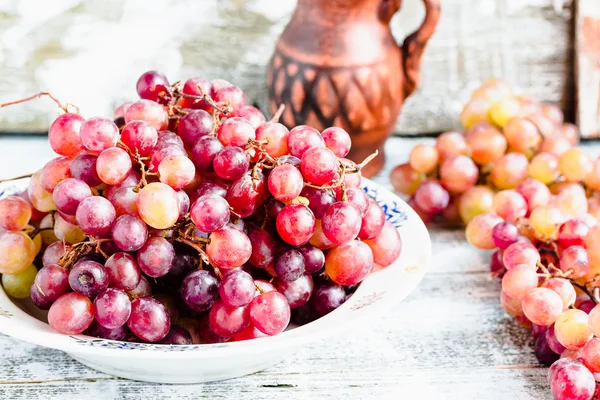 Fresh red grapes on the plate, raw fruits, whole plant foods — Stock Photo, Image