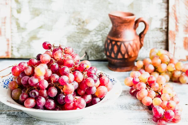 Fresh red grapes on the plate, raw fruits, whole plant foods — Stock Photo, Image