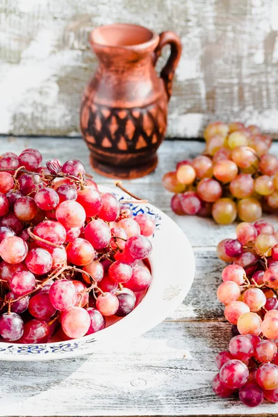 Uvas vermelhas frescas no prato, alimentos vegetais integrais, foco seletivo — Fotografia de Stock
