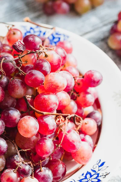 Uvas vermelhas frescas no prato, frutas cruas, alimentos integrais vegetais — Fotografia de Stock