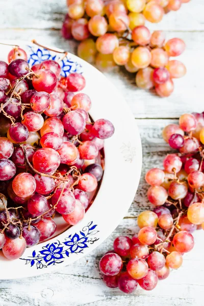 Fresh red grapes on the plate, raw fruits, whole plant foods — Stock Photo, Image