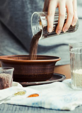 bir tabak içinde cam çatlak yemek pişirmek için keten tohumu kaydırmaya