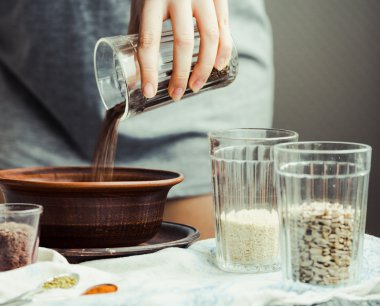 bir tabak içinde cam çatlak yemek pişirmek için keten tohumu kaydırmaya