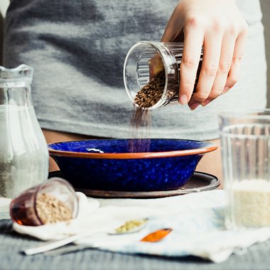 bir tabak içinde cam çatlak yemek pişirmek için keten tohumu kaydırmaya