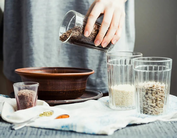 bir tabak içinde cam çatlak yemek pişirmek için keten tohumu kaydırmaya