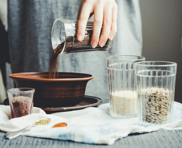 bir tabak içinde cam çatlak yemek pişirmek için keten tohumu kaydırmaya