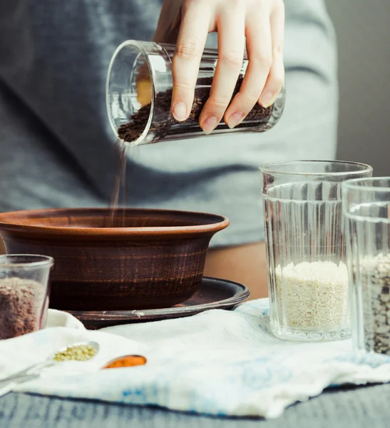 bir tabak içinde cam çatlak yemek pişirmek için keten tohumu kaydırmaya