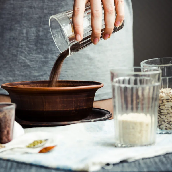 bir tabak içinde cam çatlak yemek pişirmek için keten tohumu kaydırmaya