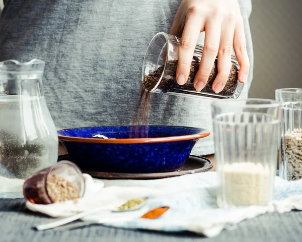 bir tabak içinde cam çatlak yemek pişirmek için keten tohumu kaydırmaya