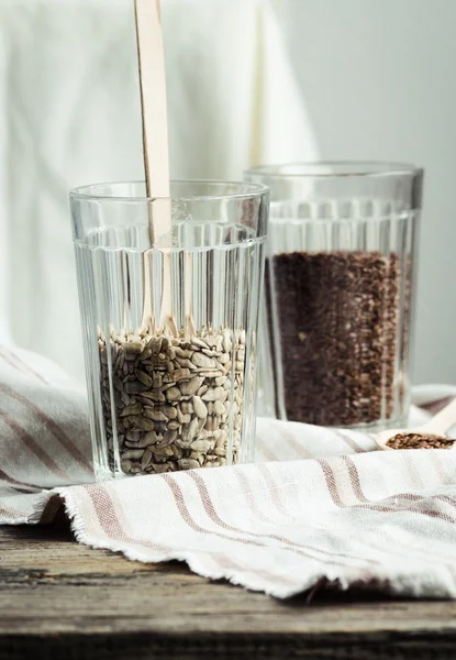 bir cam tahta kaşık ile keten ve ayçiçeği tohumu