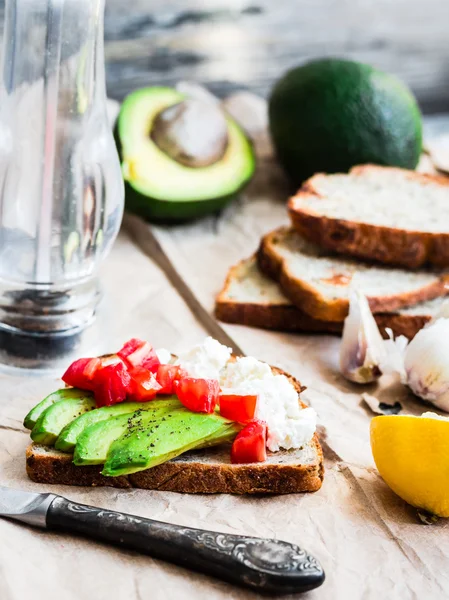 Toast mit frischer Avocado, Tomaten und Ziegenkäse, vegetarische sna — Stockfoto