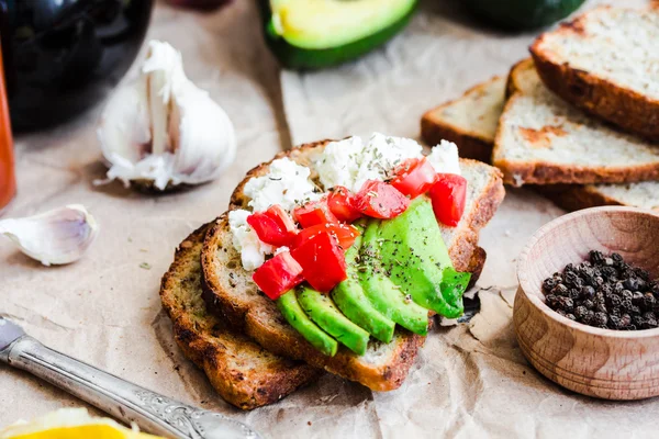 Toast mit frischer Avocado, Tomaten und Ziegenkäse, vegetarische sna — Stockfoto