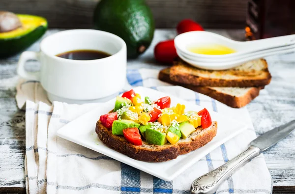 Roti panggang dengan alpukat segar, tomat dan jagung, secangkir kopi, brea — Stok Foto