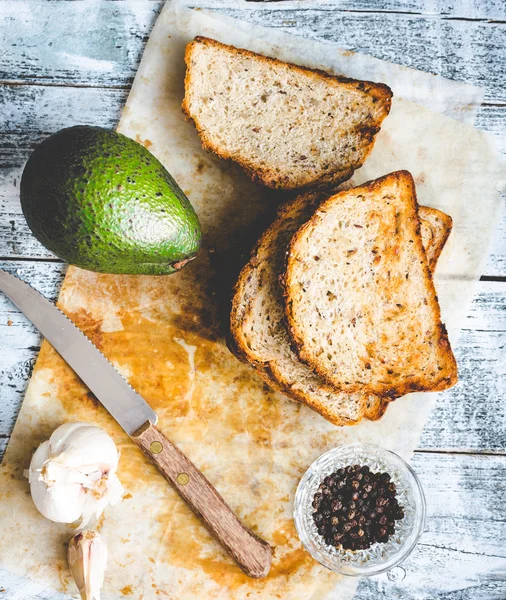 Brot und eine ganze Avocado mit Pfeffer und Knoblauch — Stockfoto