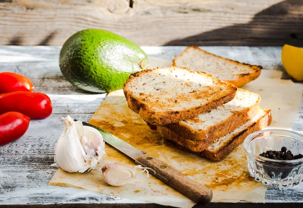 Brood en een hele avocado met peper en knoflook — Stockfoto