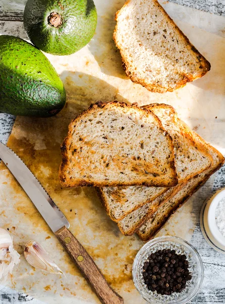 Bread and a whole avocado with cherry tomatoes, pepper and garli — Stock Photo, Image