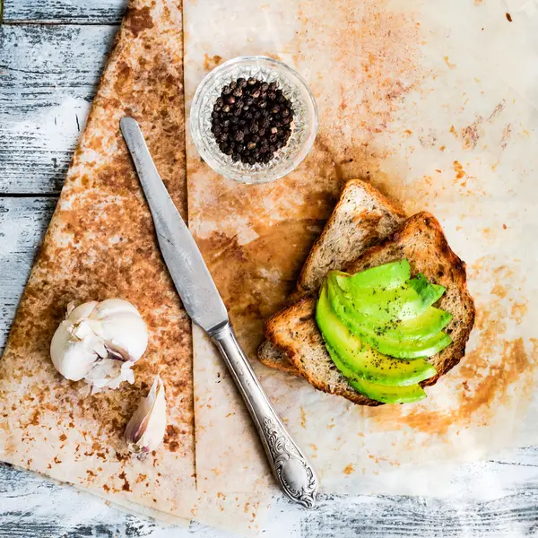 Pane tostato con avocado fresco e pepe, spuntino sano, vegetariano f — Foto Stock