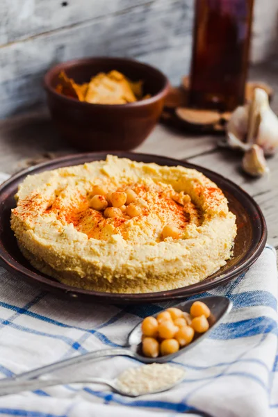 Hummus av kikärter, tahini klistra in och med paprika i en lera pla — Stockfoto