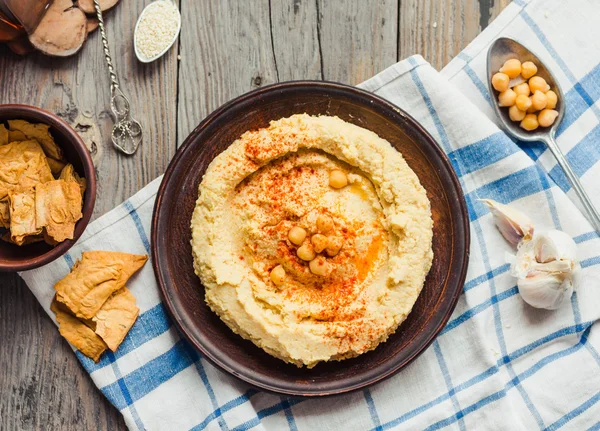 Houmous de pois chiches, pâte de tahini et au paprika, backgr rustique — Photo