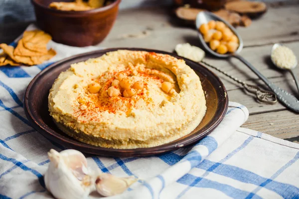 Hummus av kikärter, tahini klistra in och med paprika i en lera pla — Stockfoto