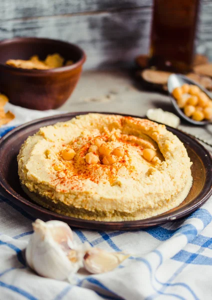 Hummus av kikärter, tahini klistra in och med paprika i en lera pla — Stockfoto
