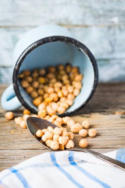 bir kaşık ve mavi bir fincan kurutulmuş nohut 