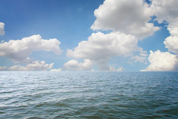 Krajina na pozadí moře a modrou oblohu s mraky retuš — Stock fotografie