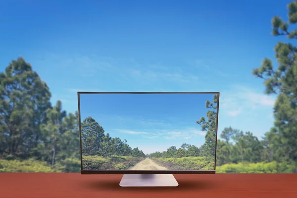 O computador na mesa e natureza de fundo — Fotografia de Stock