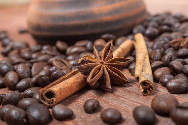 kahve çekirdekleri ve baharatlar ahşap bir masada.
