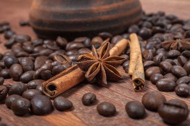 kahve çekirdekleri ve baharatlar ahşap bir masada.