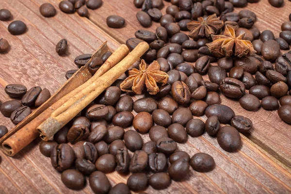 Coffee beans and spices on a wooden table — Stock Photo, Image